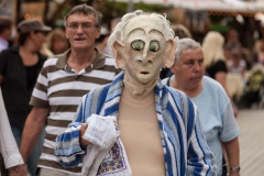 Maskenfigur geht mit Bademantel spazieren