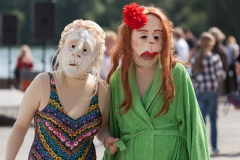 Zwei Maskenspielerinnen gehen spazieren mit Bademantel und Badehose