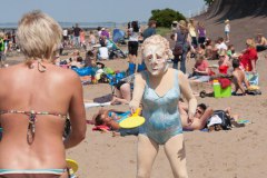 Maskenspielerinnen mit Badehosen am Strand 