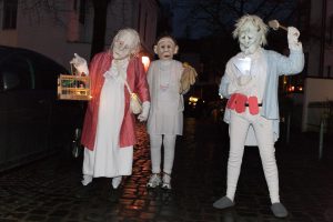 Drei Maskenfiguren mit Schlafanzug und Vogelkäfig beim Karneval 2019 in Bremen