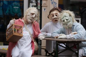 Drei Maskenfiguren mit Schlafanzug sitzen am Tisch beim Karneval 2019 in Bremen